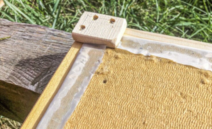 Die Holzfaserplatten im Deckel isolieren Wärme. Der Holzklotz an der Ecke ist einer von Vieren und lässt einen Abstand entstehen - zum Blechdeckel, der oben drauf gelegt wird. Dort kann die Luffeuchtigkeit abziehen. | © Markus Röck