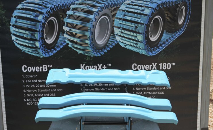 Olofsfors bietet drei neue Bogieband-Varianten an. Vor dem Plakat ist oben ein Quereisen des CoverX 180 abgebildet, darunter das Kovax und das Kovax+, das 20 % stärkere Quereisen besitzt | © O. Gabriel