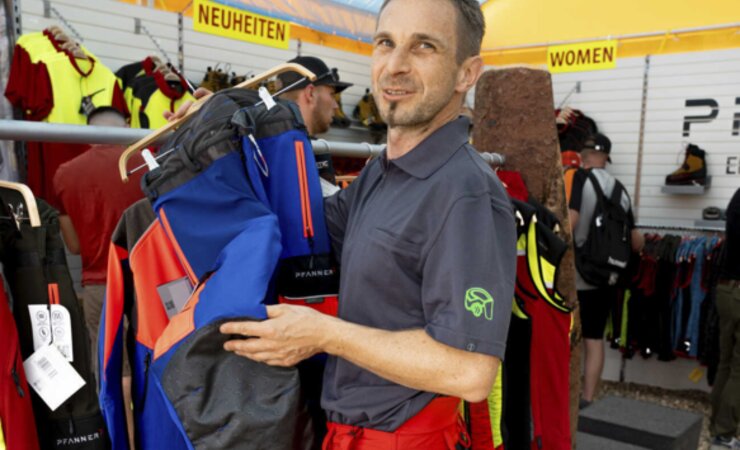 Peter Felder vom Pfanner Store Schweiz trägt die extra-leichte Sommer-Schnittschutzhose Keprotec light, in seiner Hand die Arboristenhose in der neuen Farbgebung königsblau | © H. Höllerl